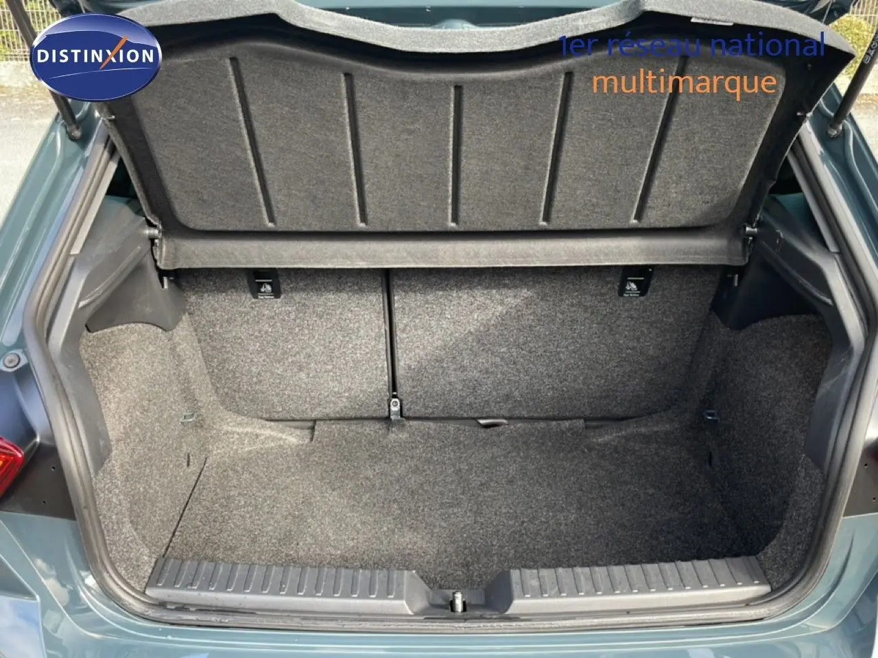 Coffre ouvert vu de l'arrière d'une SEAT Ibiza bleu fjord, montrant un espace de chargement propre et vide.