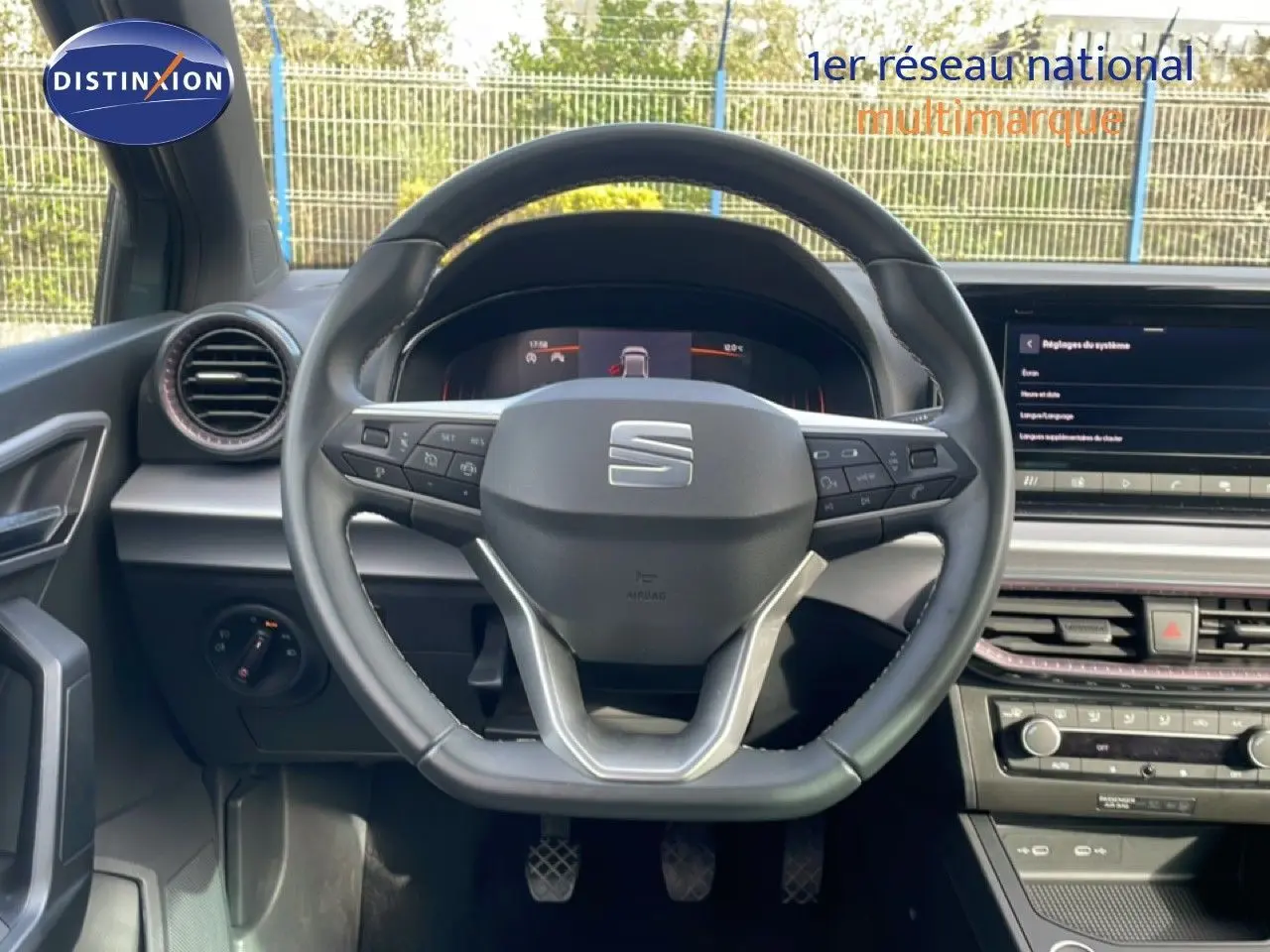 Vue centrée sur le volant noir de la SEAT Ibiza 2025, avec tableau de bord digital et console centrale moderne.