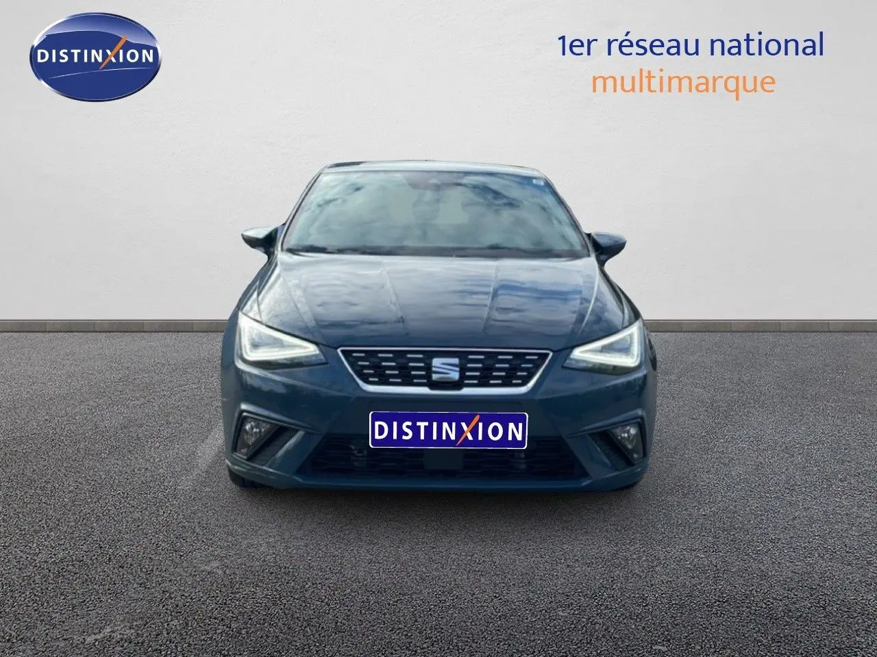 Vue avant d'une SEAT Ibiza bleu fjord 2025 avec phares LED allumés sur fond neutre.