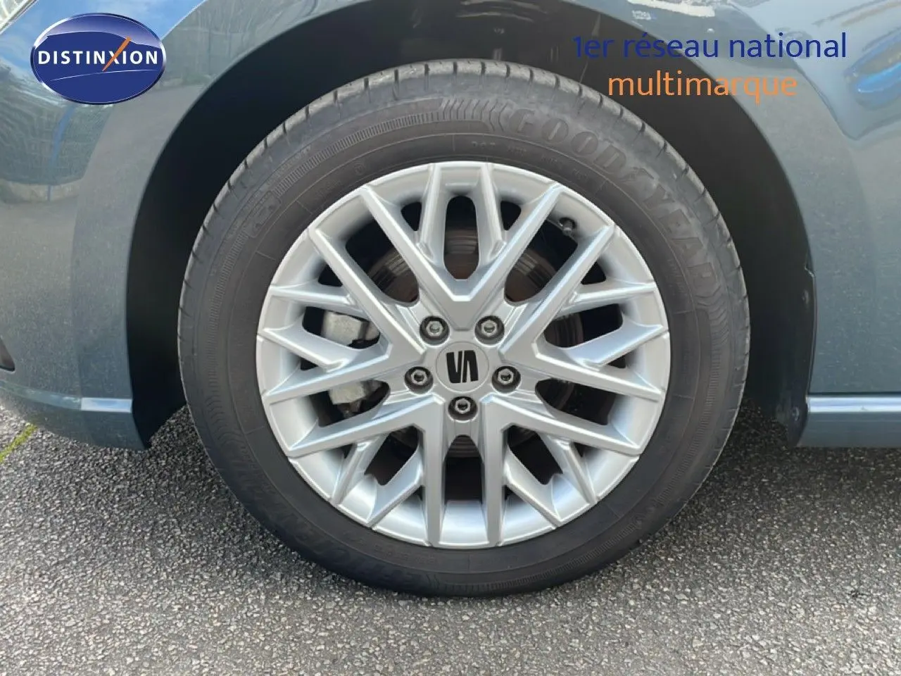 Gros plan sur la roue avant gauche d'une SEAT Ibiza bleu fjord avec jante alliage argentée à multiples branches.