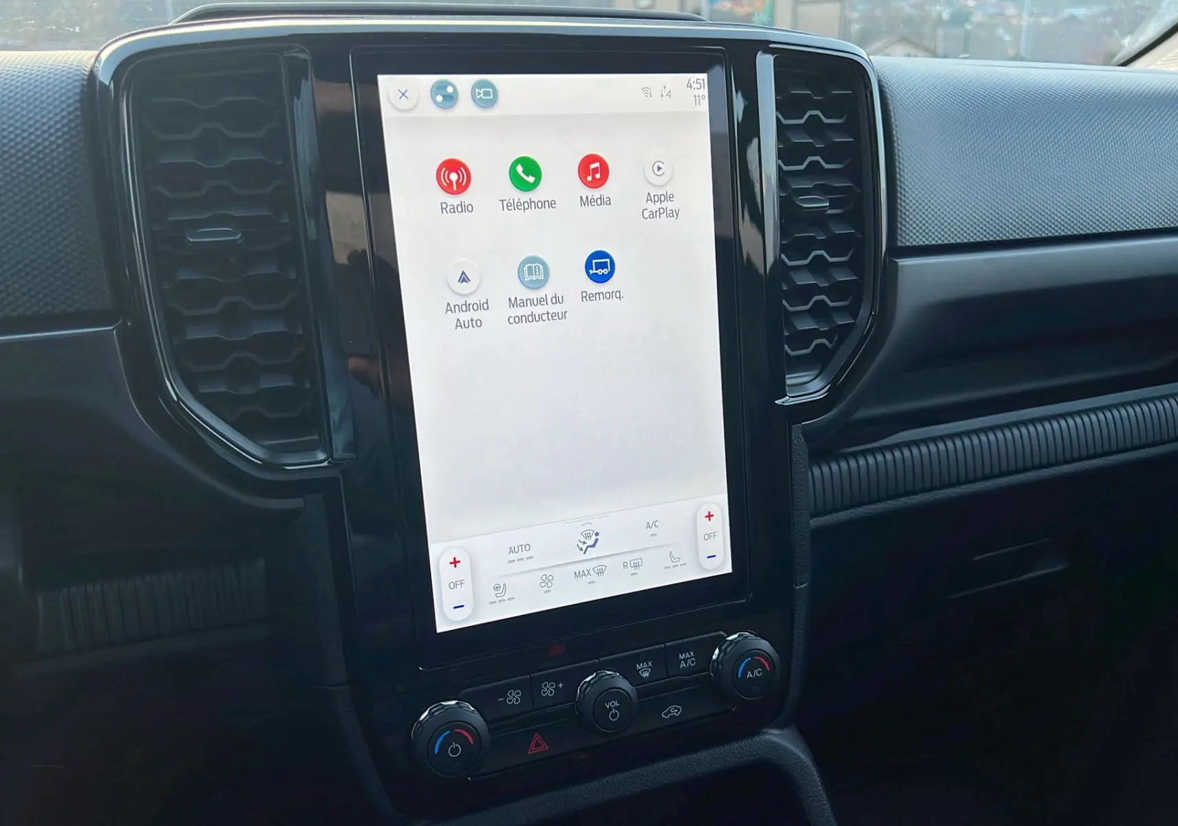 Vue intérieure centrée sur l’écran tactile vertical du Ford Ranger 2025 noir agate avec commandes climatisation et multimédia.