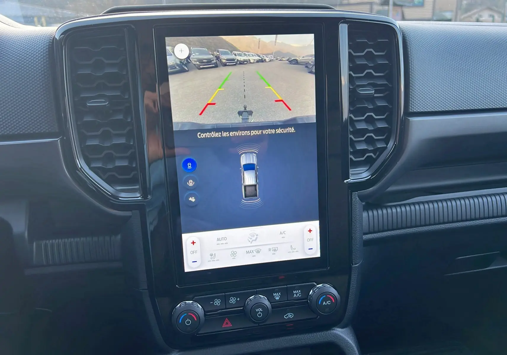 Vue rapprochée de l’écran central tactile du Ford Ranger 2025 noir agate affichant la caméra de recul et les commandes climatisation.