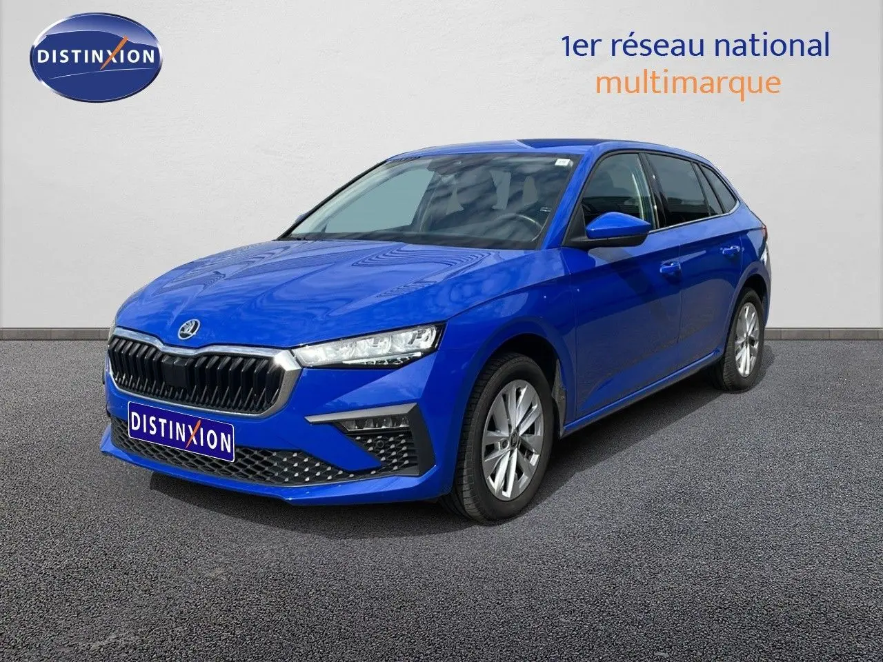 SKODA SCALA 1.0 TSI bleu racing métal en 3/4 avant droit, avec calandre noire et jantes argentées.