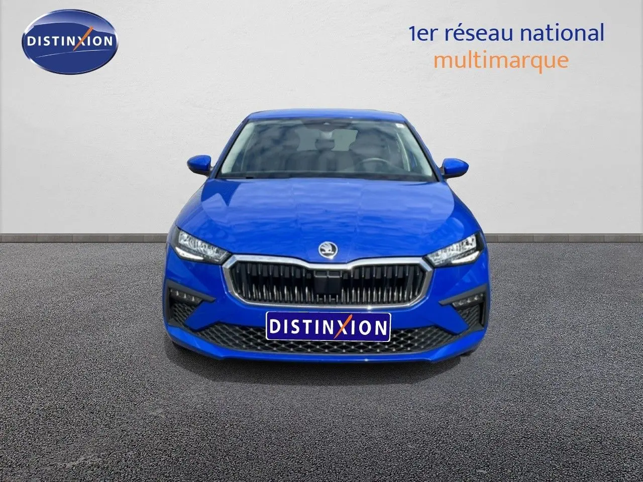 Vue frontale d'une Skoda Scala 2025 en bleu racing metal avec calandre noire et phares LED distinctifs.