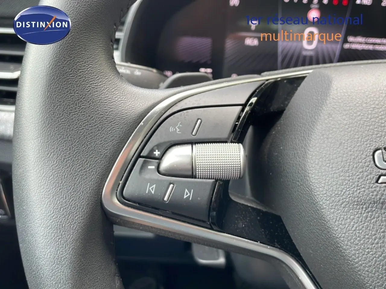 Gros plan sur les commandes gauche du volant d’une Skoda Scala 2025, volant en cuir noir avec molette crantée.