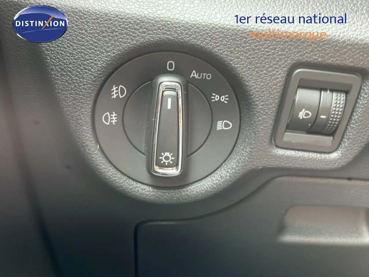 Gros plan sur le bouton de commande des phares dans l’habitacle d’une Skoda Scala 2025 bleu racing metal.
