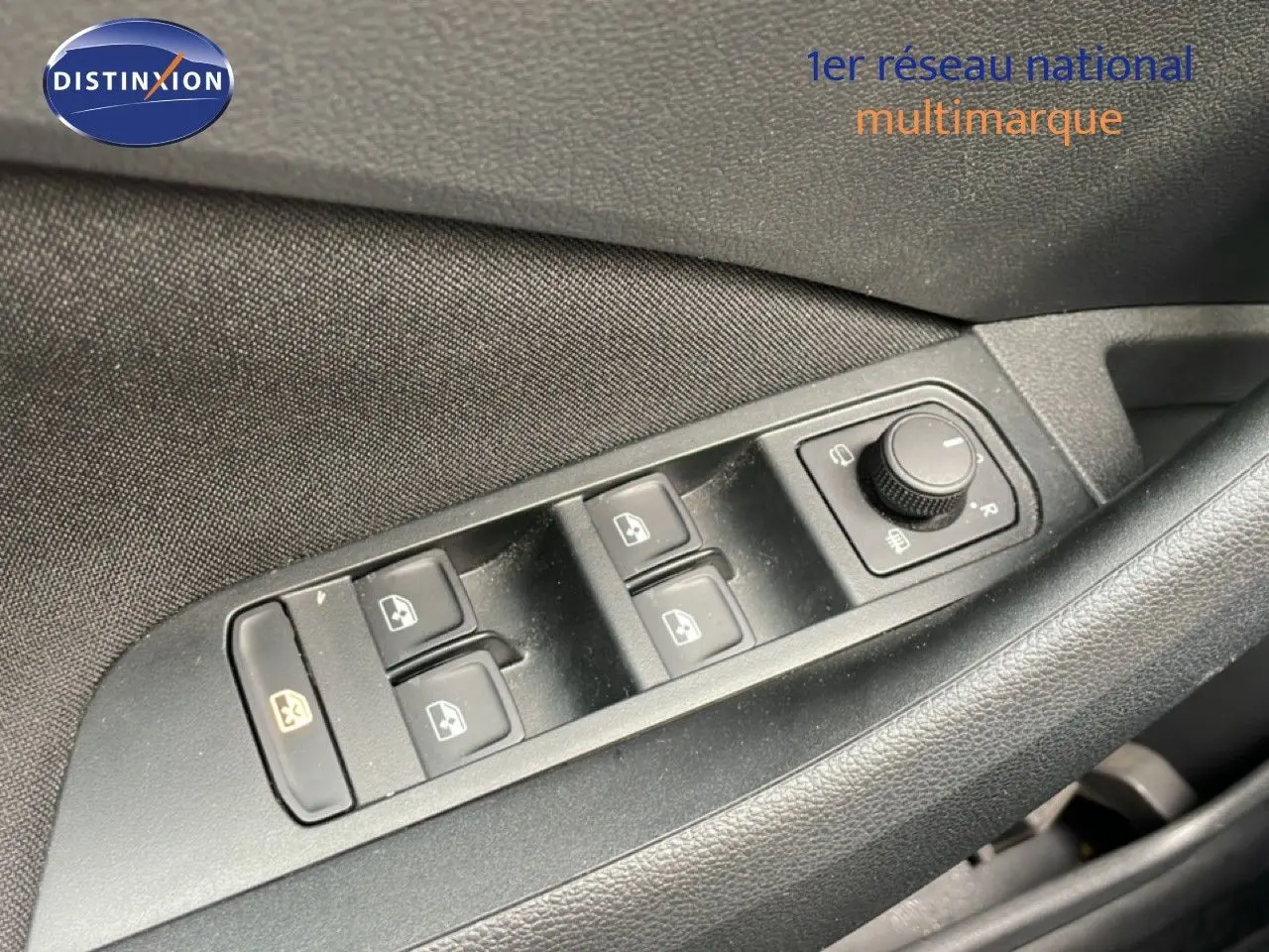 Gros plan sur les commandes de lève-vitres et réglage des rétroviseurs côté conducteur d'une Skoda Scala Bleu Racing Metal.
