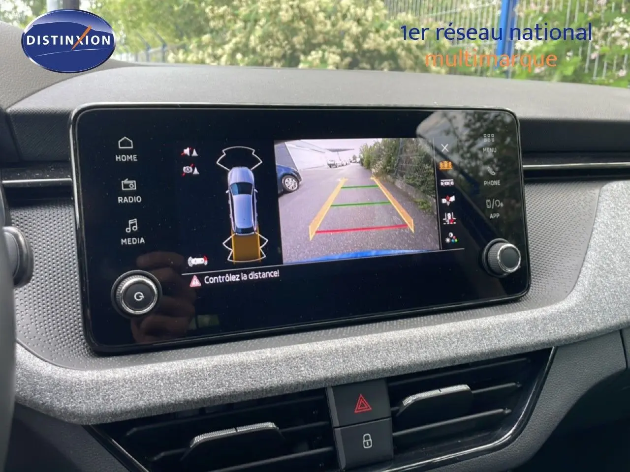 Écran central de la Skoda Scala bleu Racing Metal montrant la caméra de recul avec guidage de trajectoire.