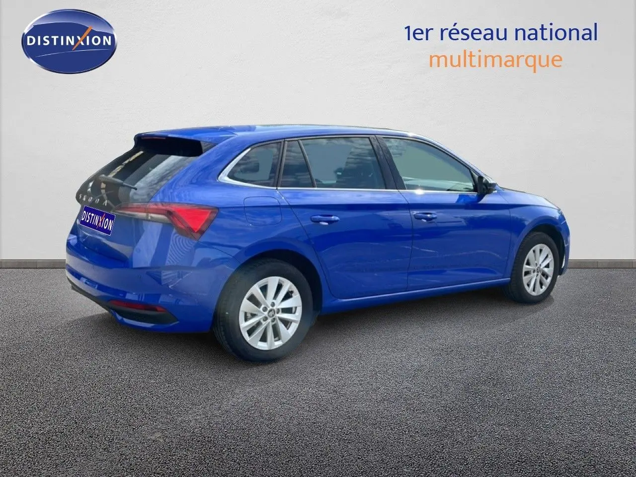 Vue 3/4 arrière droite d'une Skoda Scala bleu racing metal avec jantes alliage et feux arrière LED visibles.