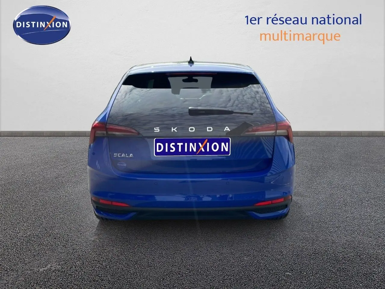Vue arrière d'une Skoda Scala bleu racing metal avec feux arrière étirés et logo distinctif sur fond neutre.