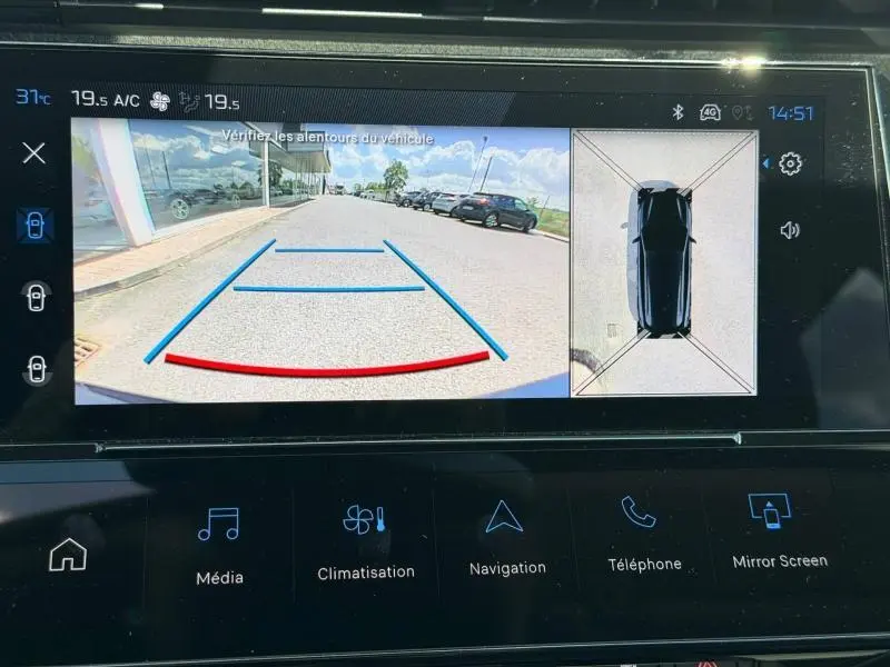 Écran de caméra de recul du Peugeot 308 SW noir Perla Nera montrant l’arrière avec lignes de guidage et vue aérienne du véhicule.