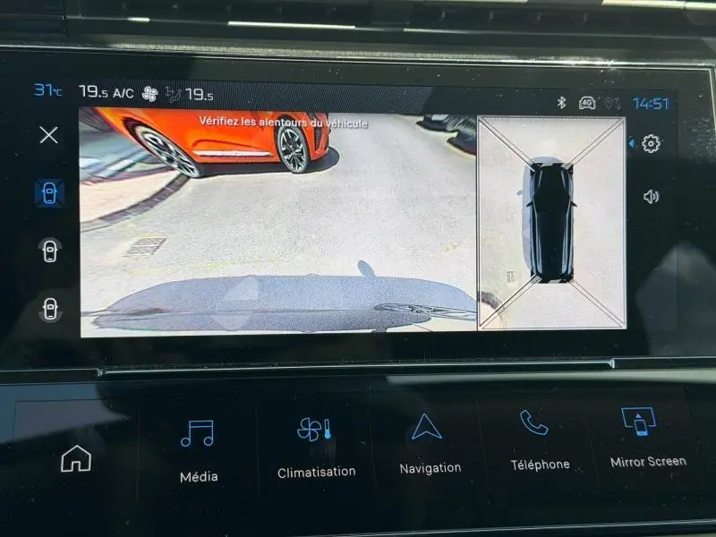 Vue écran caméra de recul du Peugeot 308 SW hybride noir Perla Nera, avec affichage 360° et véhicule orange à l'arrière gauche.
