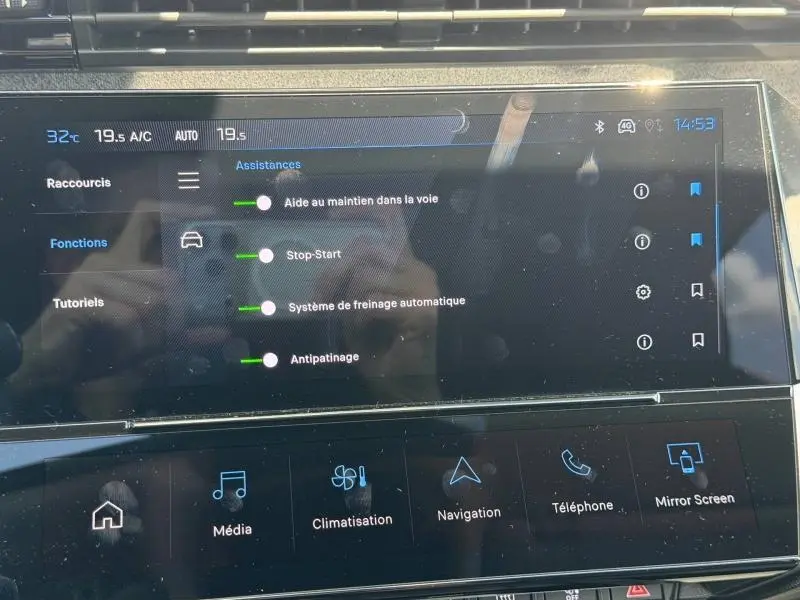 Écran tactile intérieur du Peugeot 308 SW 1.2 Hybrid 2025 affichant les aides à la conduite et la climatisation.