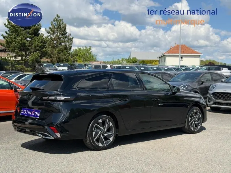 Peugeot 308 SW 1.2 Hybrid 145ch Allure en Noir Perla Nera, vue 3/4 arrière droit sur parking ensoleillé.
