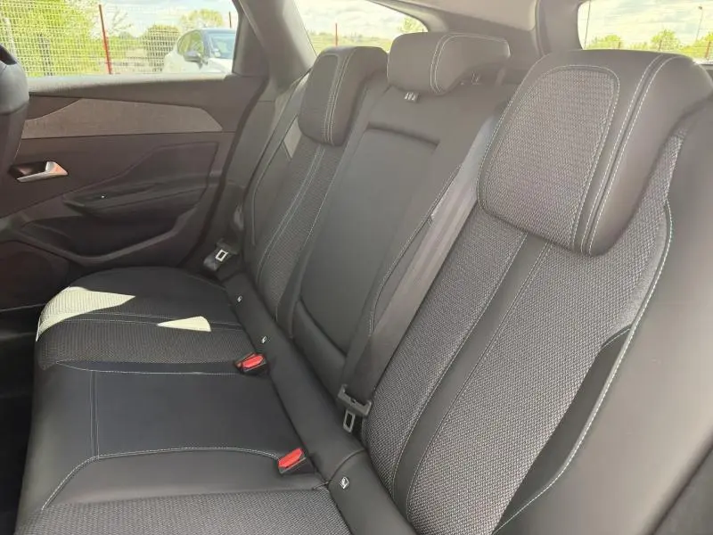 Vue intérieure côté droit des sièges arrière en tissu noir et surpiqûres blanches du Peugeot 308 SW 1.2 Hybrid 145ch Allure 2025.