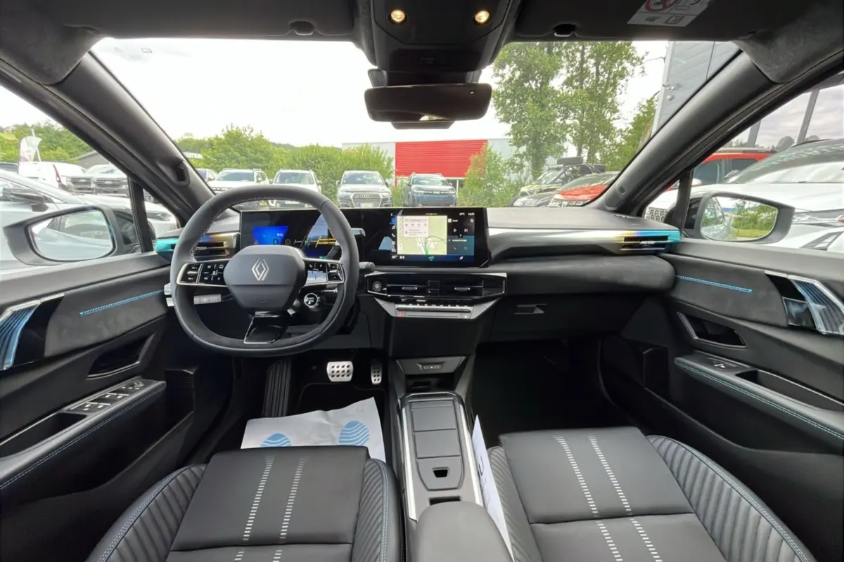 Vue intérieure avant de la Renault Clio 6 E-Tech Esprit Alpine avec tableau de bord numérique et finitions noires et bleues.