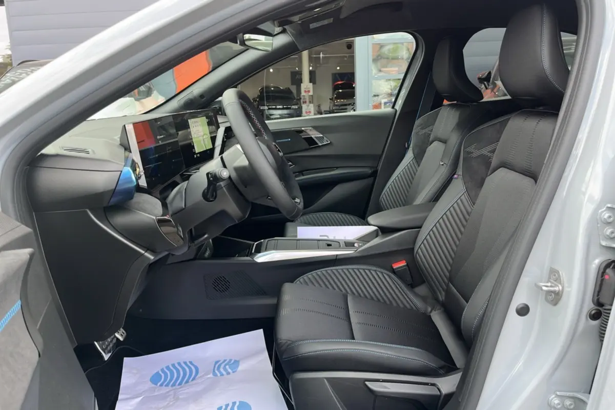 Vue intérieure côté conducteur de la Renault Clio 6 E-Tech 160 Esprit Alpine avec sièges sport noirs et tableau de bord numérique.
