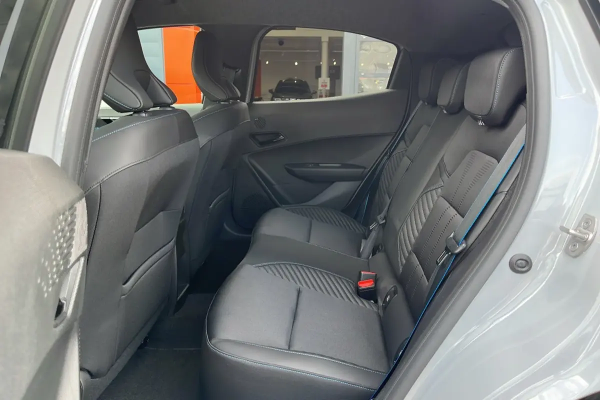 Vue intérieure côté droit sur la banquette arrière en cuir et tissu noir avec surpiqûres bleues de la Renault Clio Gris Rafale 2026.
