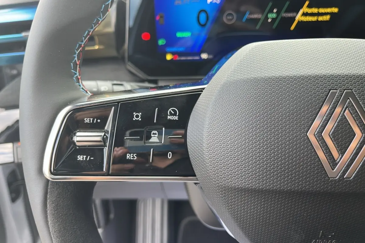 Gros plan sur le volant multifonctions de la Renault Clio 6 E-Tech 160 Esprit Alpine avec commandes de régulateur.