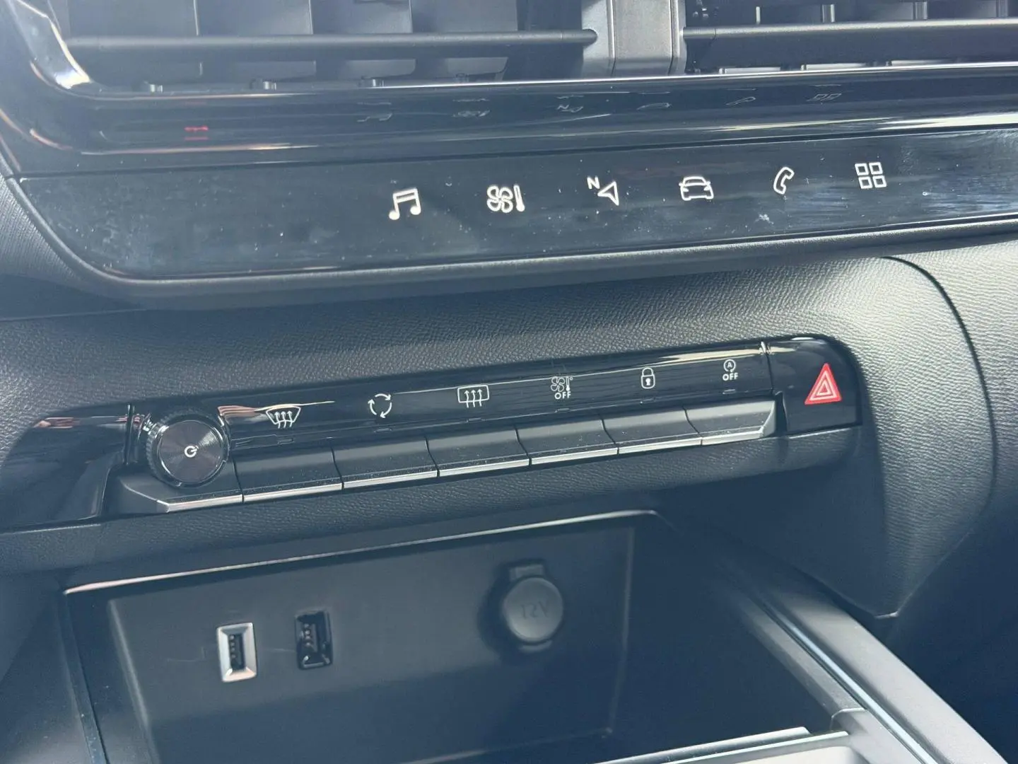 Détail de la console centrale noire du Citroën C5 Aircross 2025 avec commandes tactiles et prises USB et 12V visibles.
