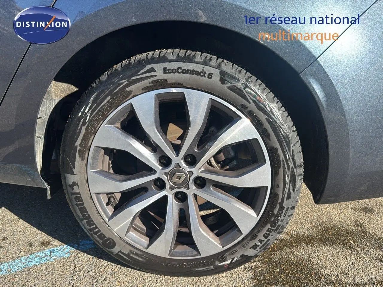 Gros plan sur la roue avant droite d'une Renault Mégane Break gris titanium avec jante alliage à 10 branches.