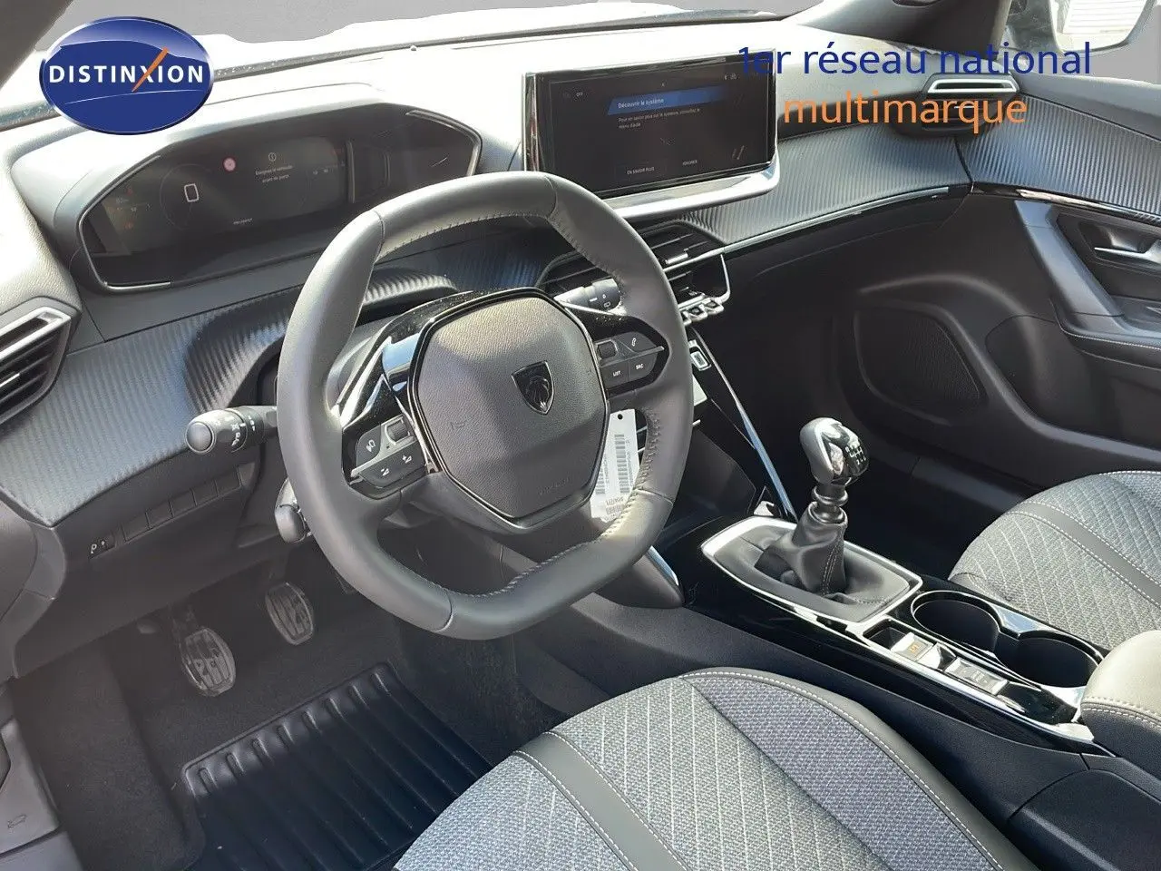 Intérieur du Peugeot 2008 2025, vue côté conducteur sur le volant compact, levier de vitesse manuel et écran tactile central.