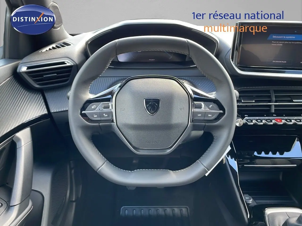 Vue rapprochée du volant cuir noir et du tableau de bord moderne du Peugeot 2008 gris Artense 2025.