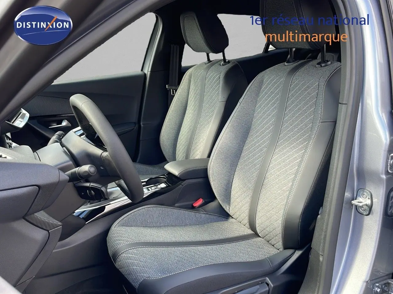 Vue intérieure côté gauche du Peugeot 2008 2025 gris Artense, sièges tissu et cuir noir avec console centrale moderne.