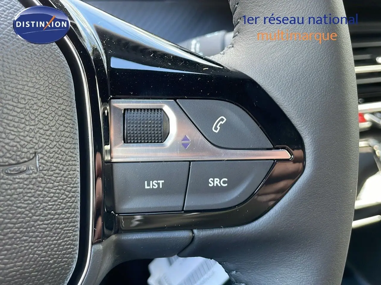 Gros plan sur les commandes gauche du volant en cuir noir du Peugeot 2008 gris Artense Metal 2025.