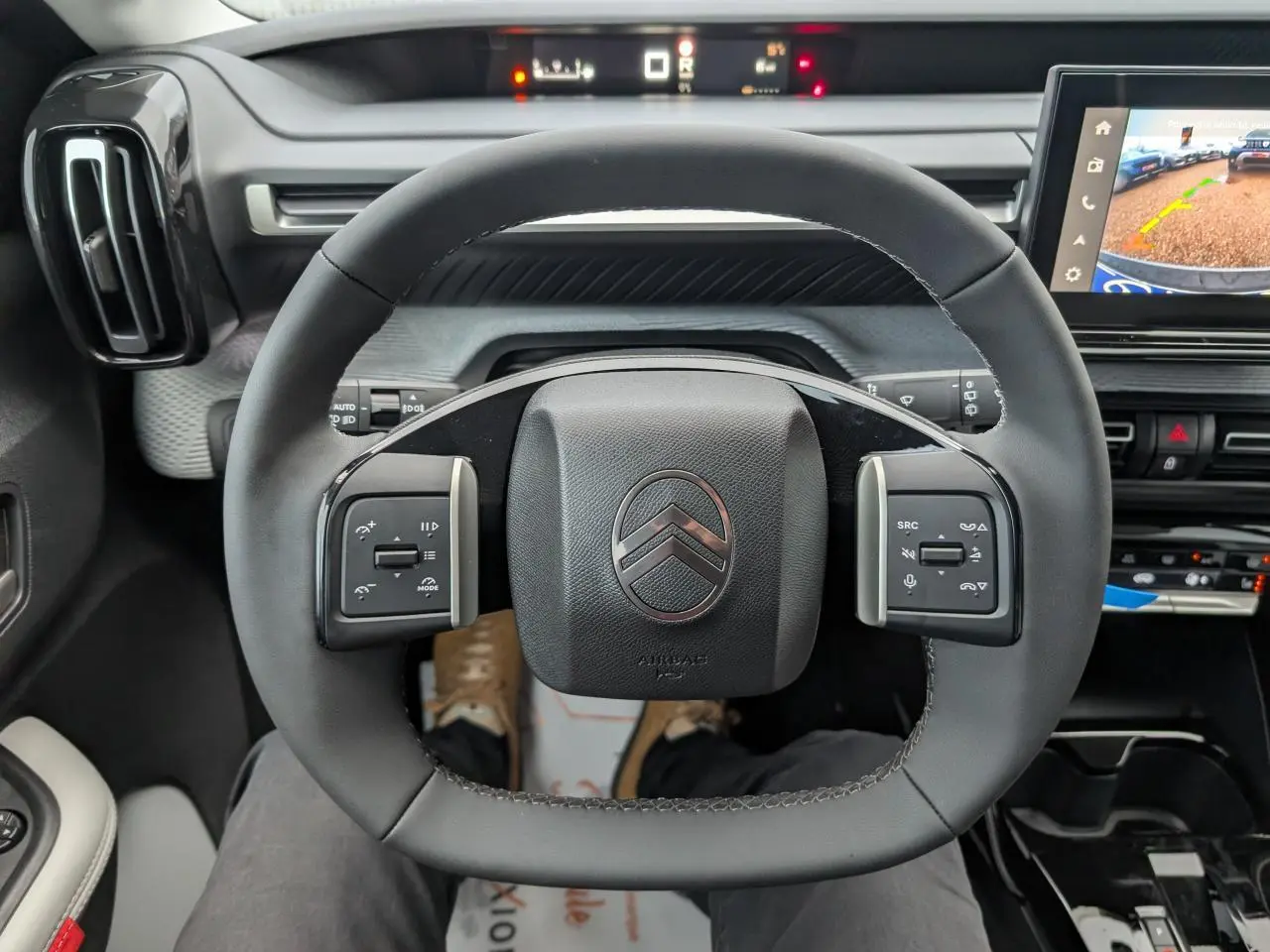 Vue intérieure centrée sur le volant multifonctions noir du Citroën C3 Aircross 2025, avec écran tactile et tableau de bord digital.
