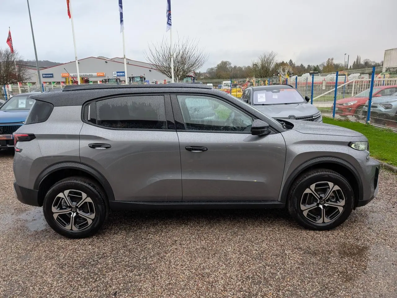 Vue de profil côté gauche d'un Citroën C3 Aircross gris métallisé avec toit noir et jantes alliage 17 pouces.
