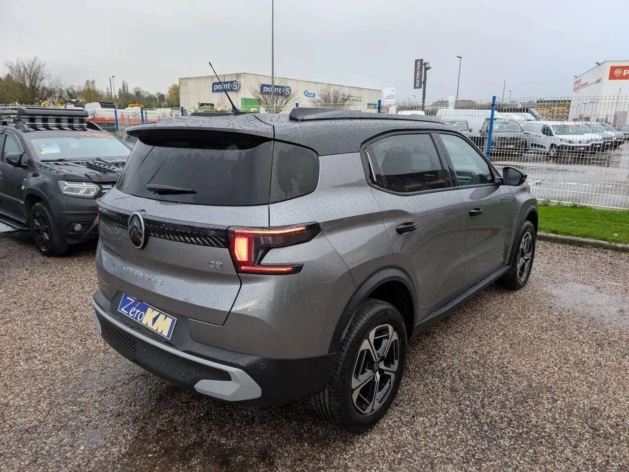 Vue 3/4 arrière droite d'une Citroën C3 Aircross 2025 gris métallisé avec toit noir et jantes alliage diamantées.