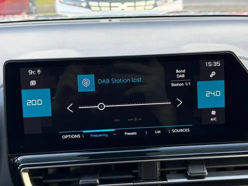 Écran tactile central du tableau de bord du Citroën C5 Aircross 2024, affichant la radio DAB et la climatisation.