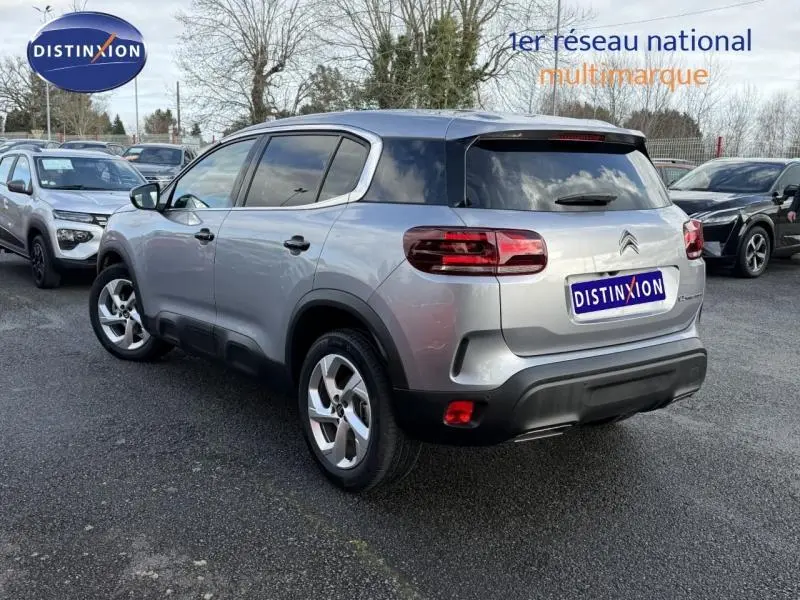 Vue 3/4 arrière d'un Citroën C5 Aircross gris 2024 avec feux arrière distinctifs et jantes alliage.