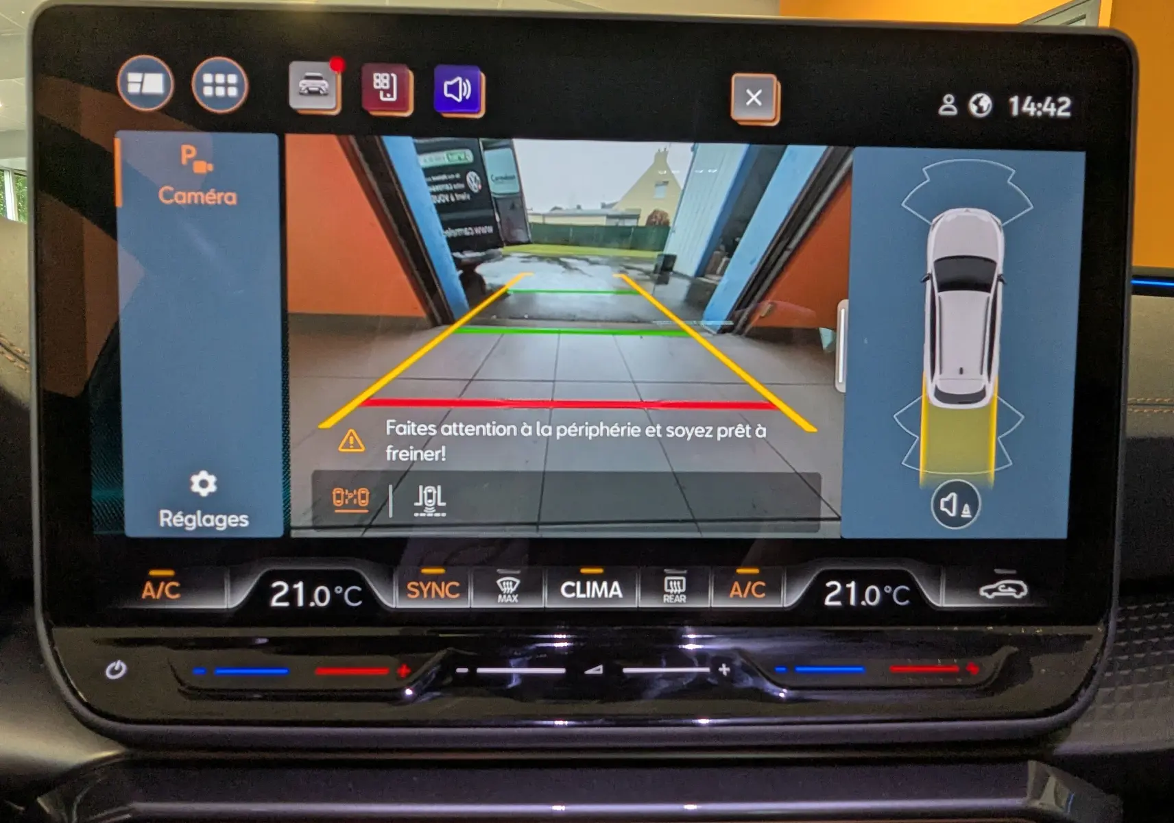 Écran tactile de la caméra de recul du CUPRA Leon ST gris, affichant les lignes de guidage et alertes de freinage.