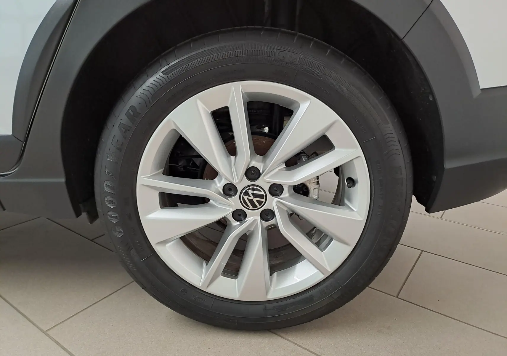 Gros plan sur la roue avant droite du Volkswagen Taigo 2025 en peinture métallisée Reflet d'argent avec jante alliage à cinq branches doubles.