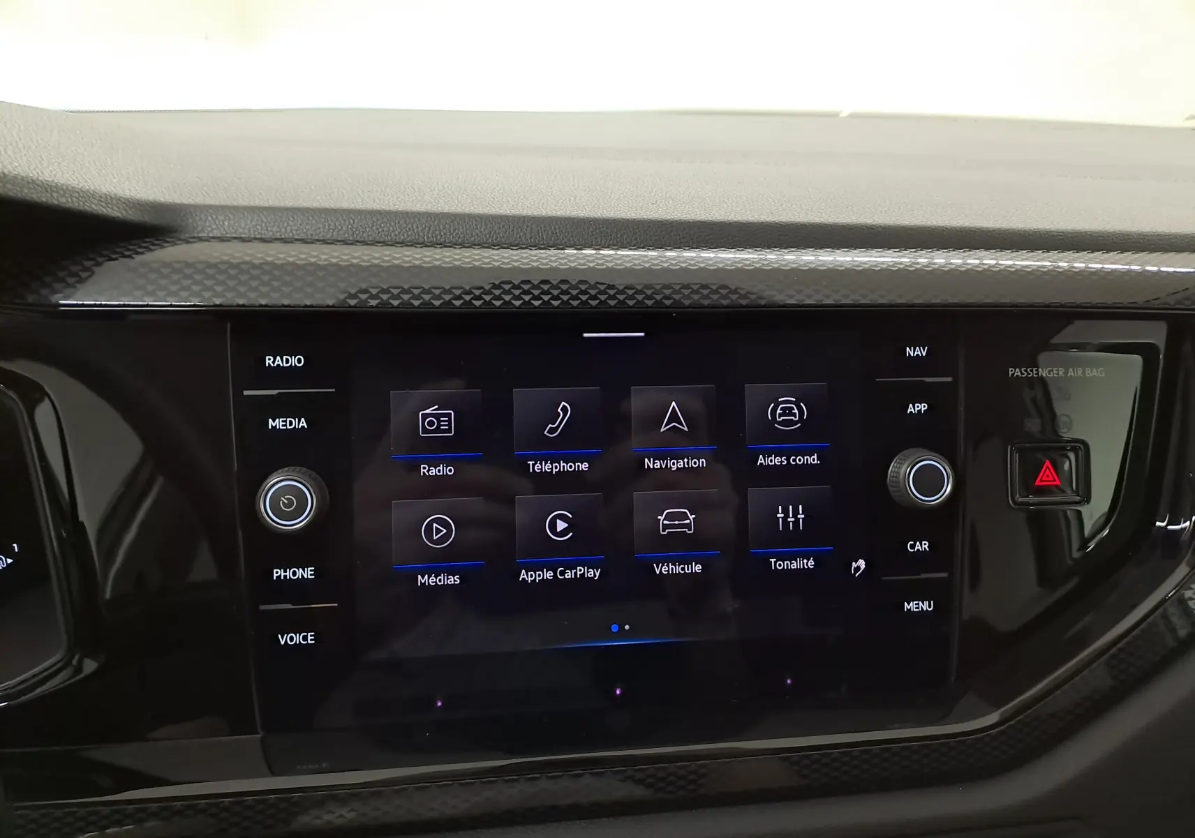 Écran tactile central du Volkswagen Taigo 2025 avec interface multimédia et commandes autour en finition noire brillante.