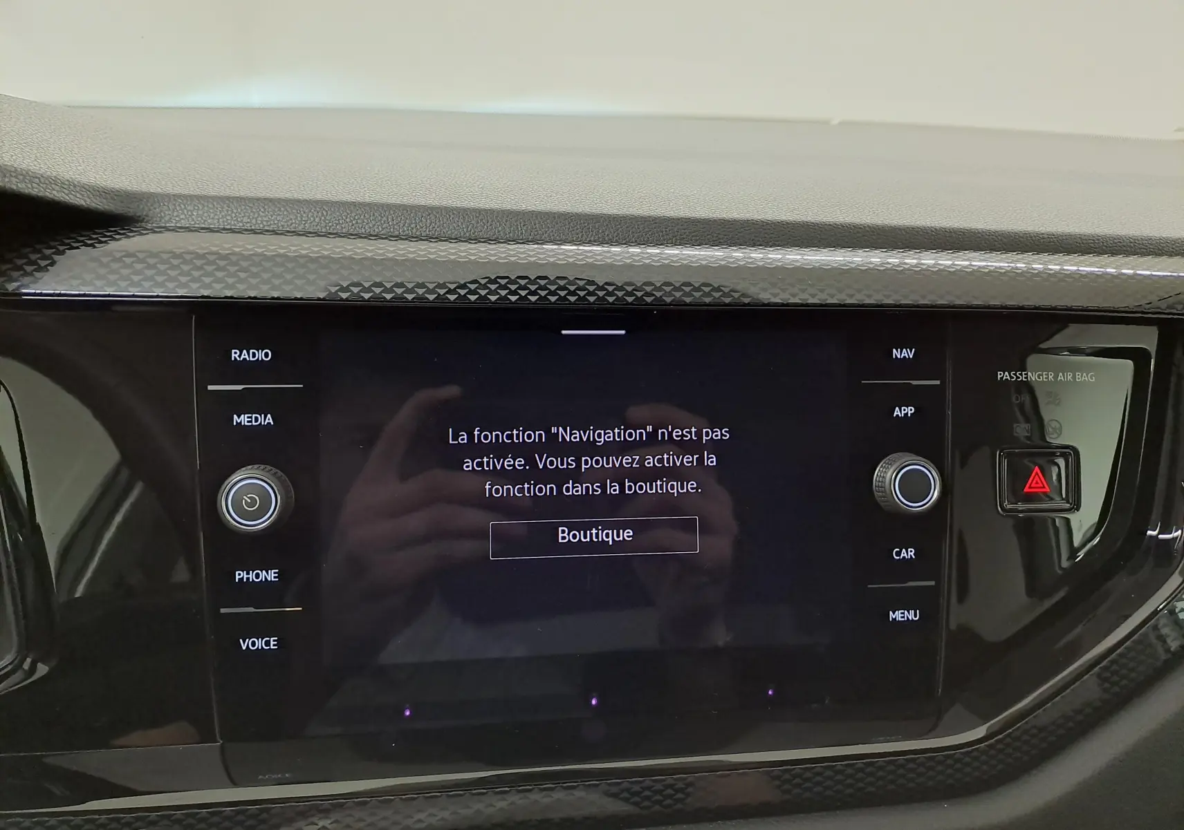 Écran tactile central du Volkswagen Taigo 2025 avec message d'activation de la navigation, entouré de boutons noirs brillants.