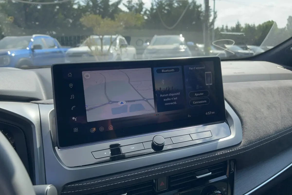 Vue rapprochée de l’écran tactile central du tableau de bord du Nissan Qashqai gris squale, affichant la navigation GPS.