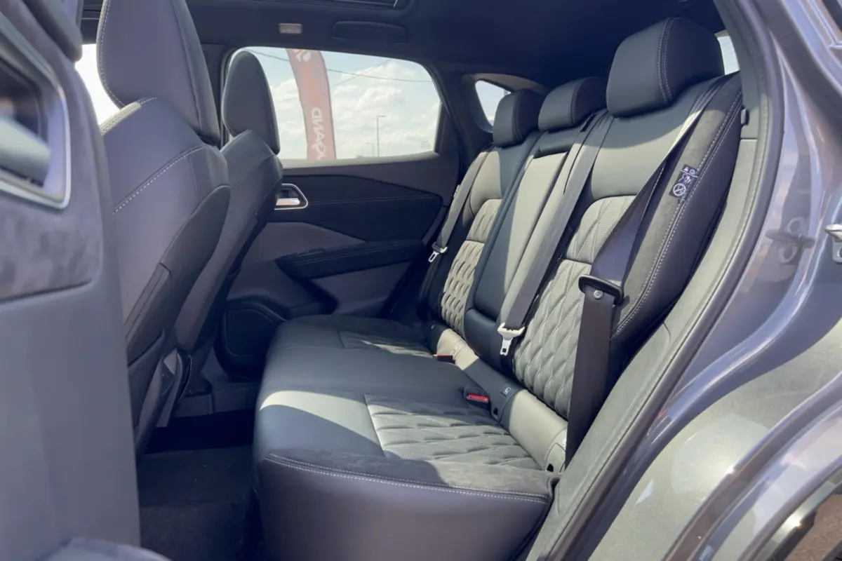 Vue latérale droite de l’intérieur arrière du Nissan Qashqai E-POWER 205 Tekna Plus avec sellerie cuir noire et détails matelassés.
