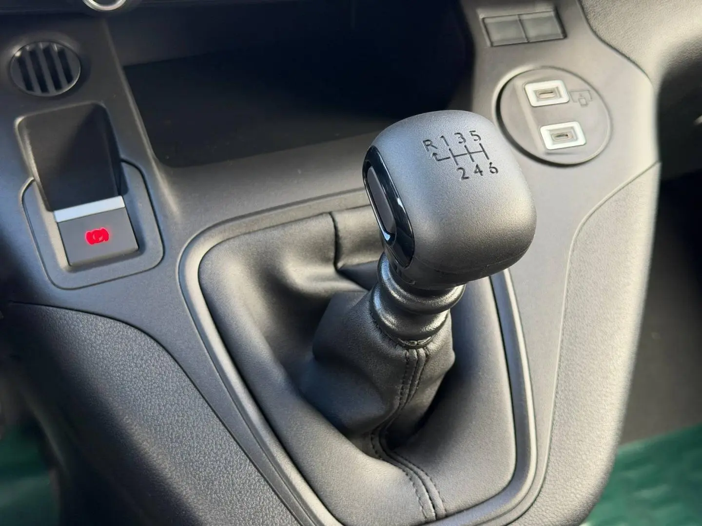 Gros plan sur le levier de vitesses manuel noir du Peugeot Partner M Diesel 100ch PACK CONFORT, intérieur gris.