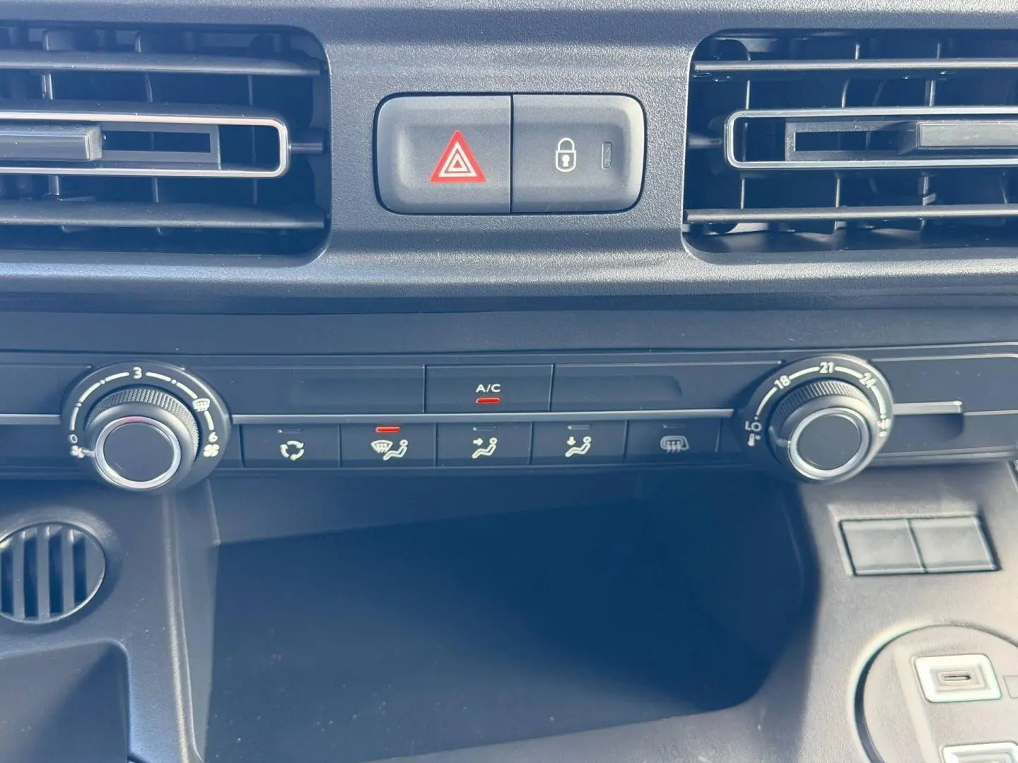 Vue rapprochée du tableau de bord du Peugeot Partner 2026 montrant les commandes de climatisation et ventilation.