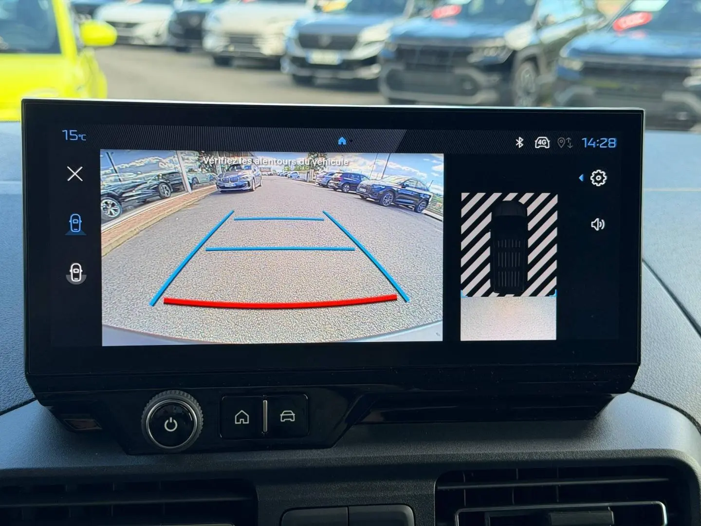 Écran de caméra de recul du Peugeot Partner blanc Icy, vue arrière avec lignes d’aide au stationnement visibles.