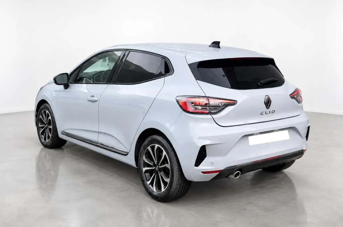 Vue 3/4 arrière gauche d'une Renault Clio gris rafale avec vitres surteintées et jantes alliage noires.