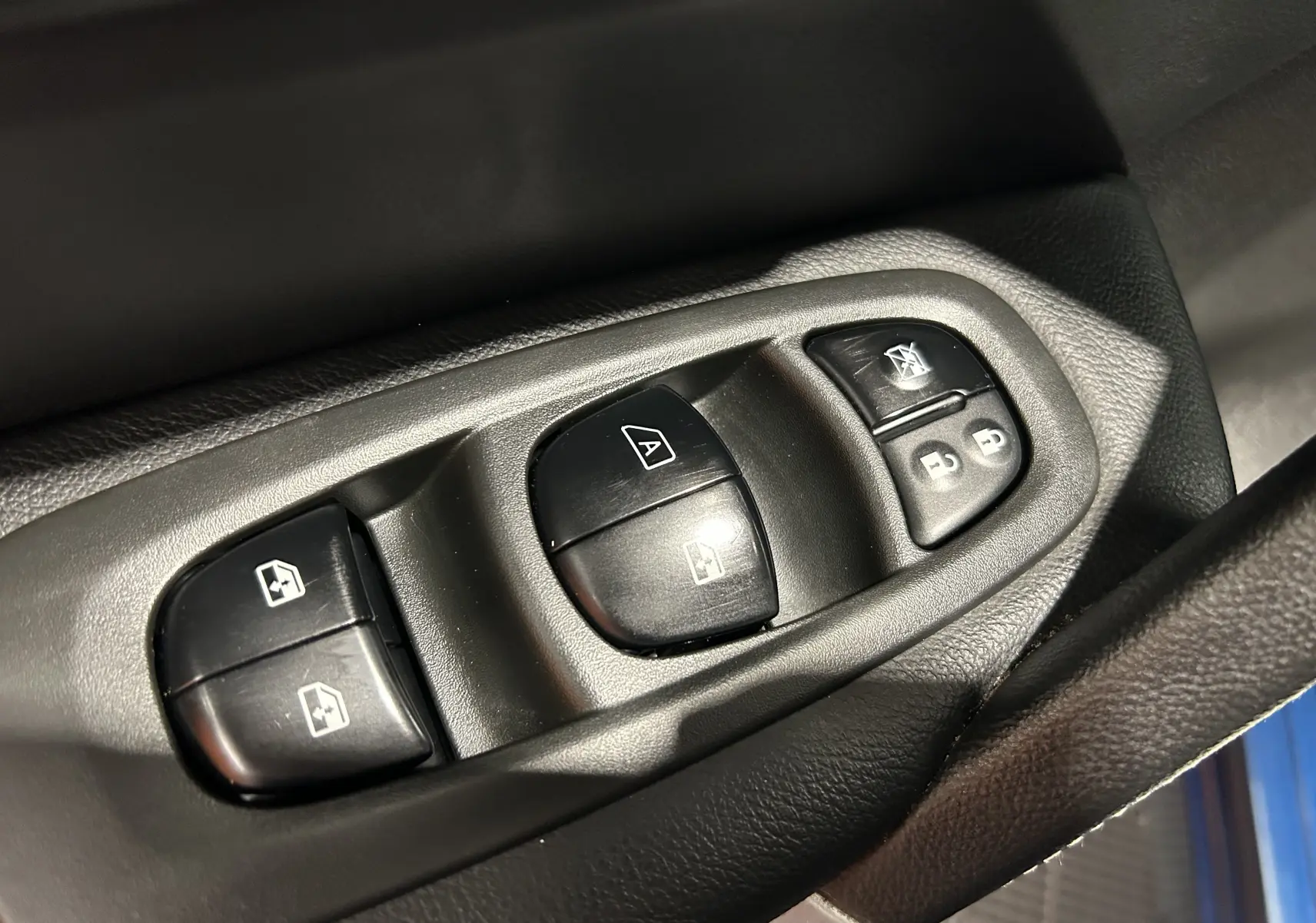 Gros plan sur les commandes de lève-vitres et verrouillage de porte côté conducteur du Renault Kadjar 2017.