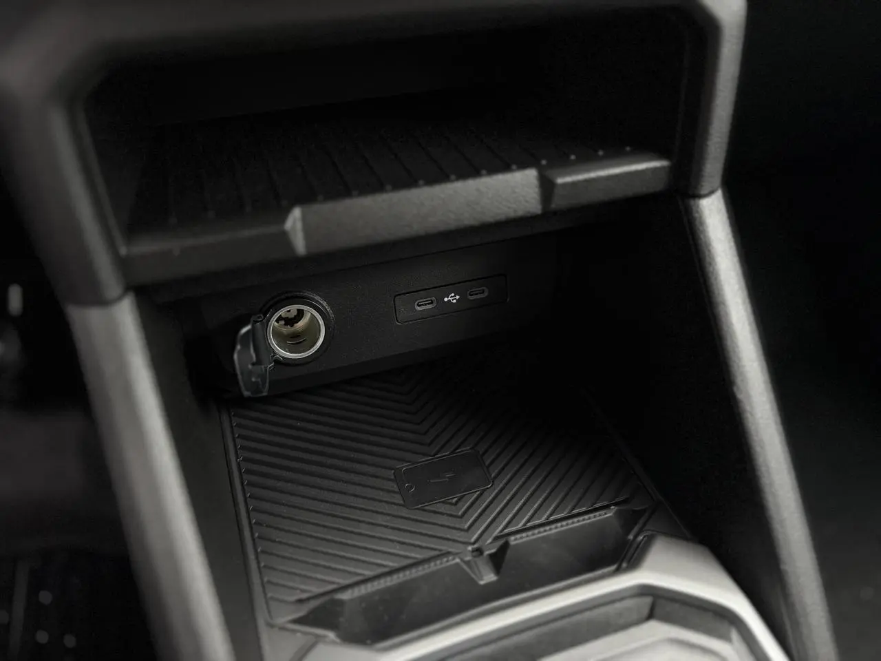 Gros plan sur les prises USB type C et prise 12V à l'arrière de la console centrale du Dacia Duster blanc Glacier 2025.