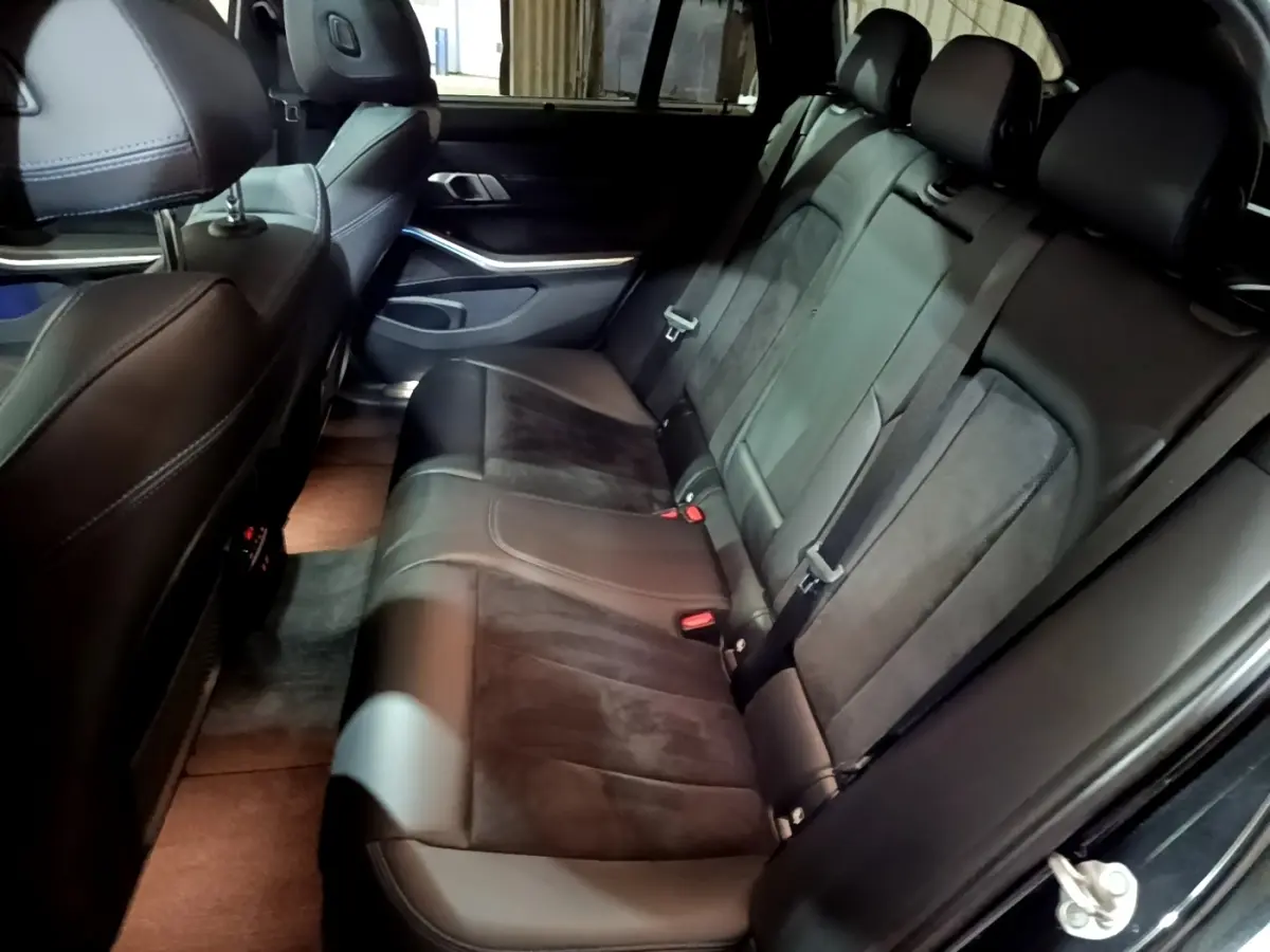 Vue côté droit de la banquette arrière en cuir noir et alcantara de la BMW Série 3 318i M Sport 2022.