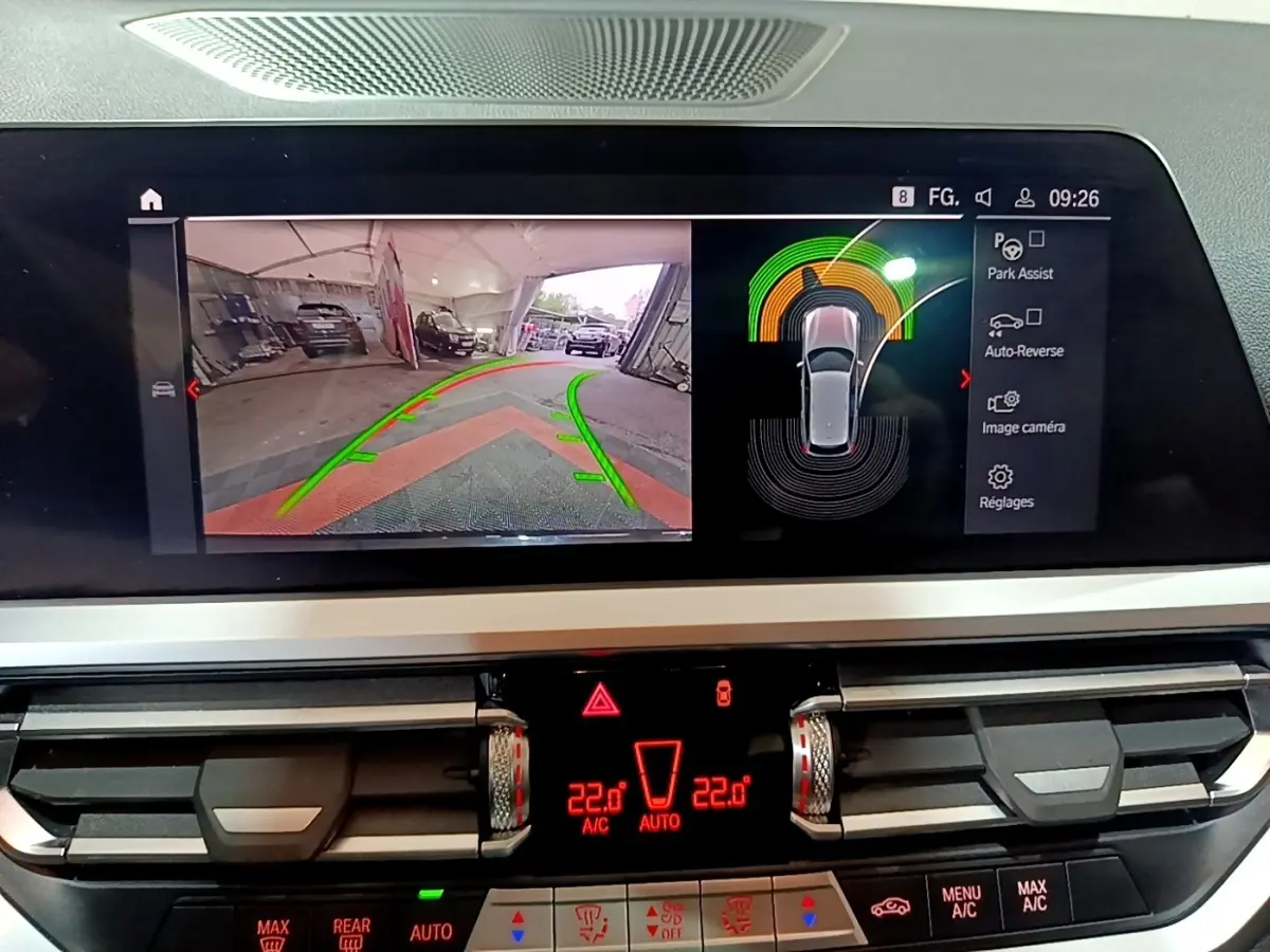 Écran tactile central de BMW Série 3 318i noir montrant l'aide au stationnement avec vue caméra arrière et capteurs.