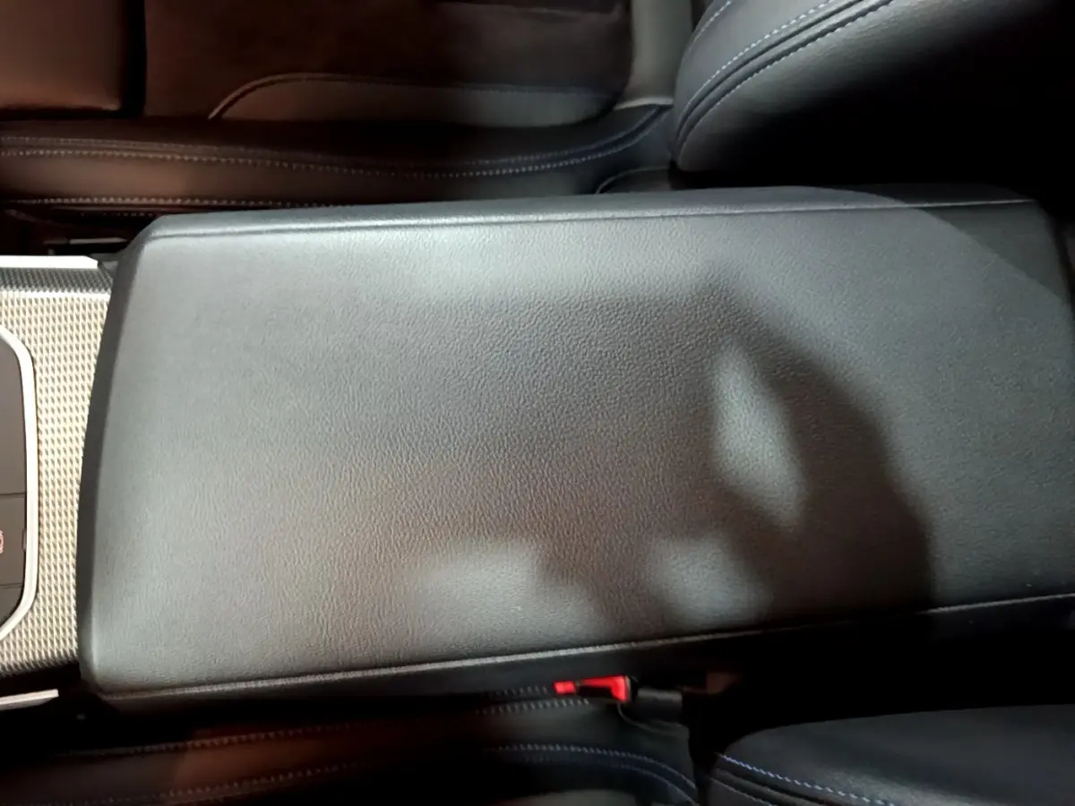 Gros plan sur l'accoudoir central en cuir noir de la BMW Série 3 318i M Sport 2022, intérieur élégant.