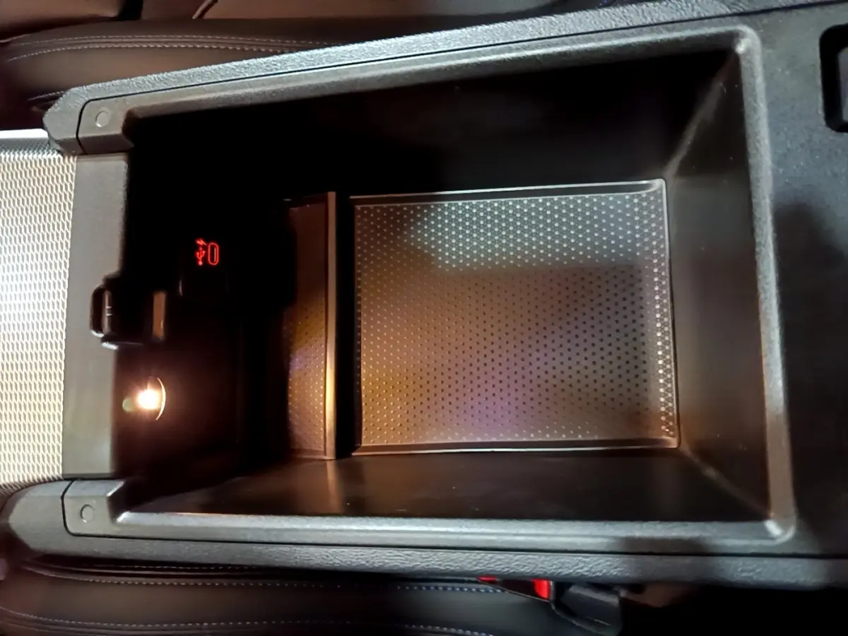 Gros plan sur la console centrale noire de la BMW Série 3 318i M Sport avec éclairage intérieur et port USB rouge.